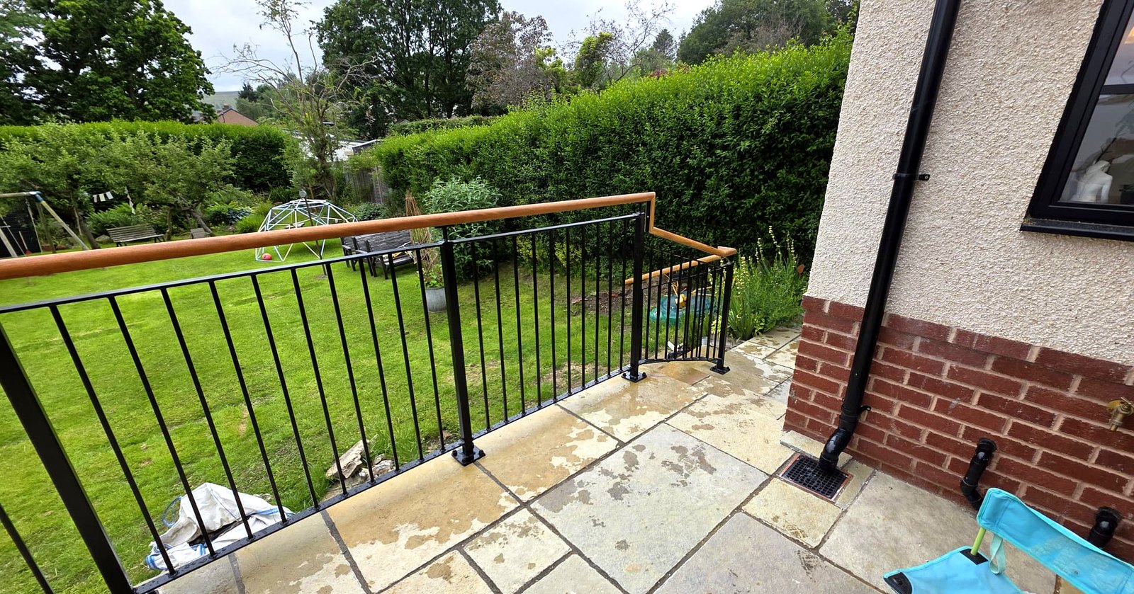 Black metal balustrade and oak handrail on external garden steps, Sheffield